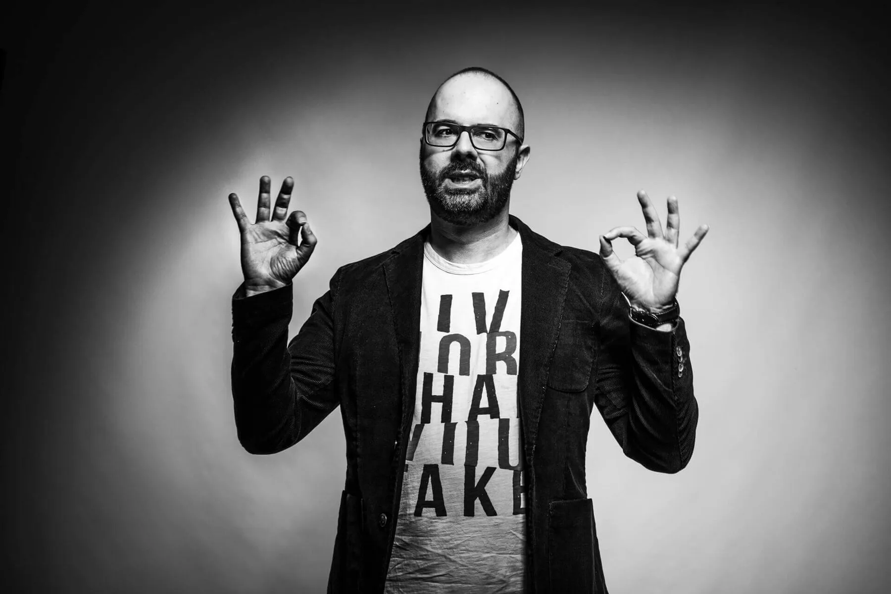 Luca Vehr in bianco e nero, con le mani alzate